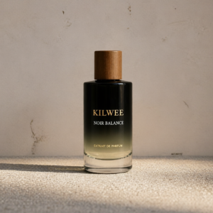 Perfume bottle labeled Kilwee Noir Balance with a wooden cap, black gradient bottle on a textured beige surface.